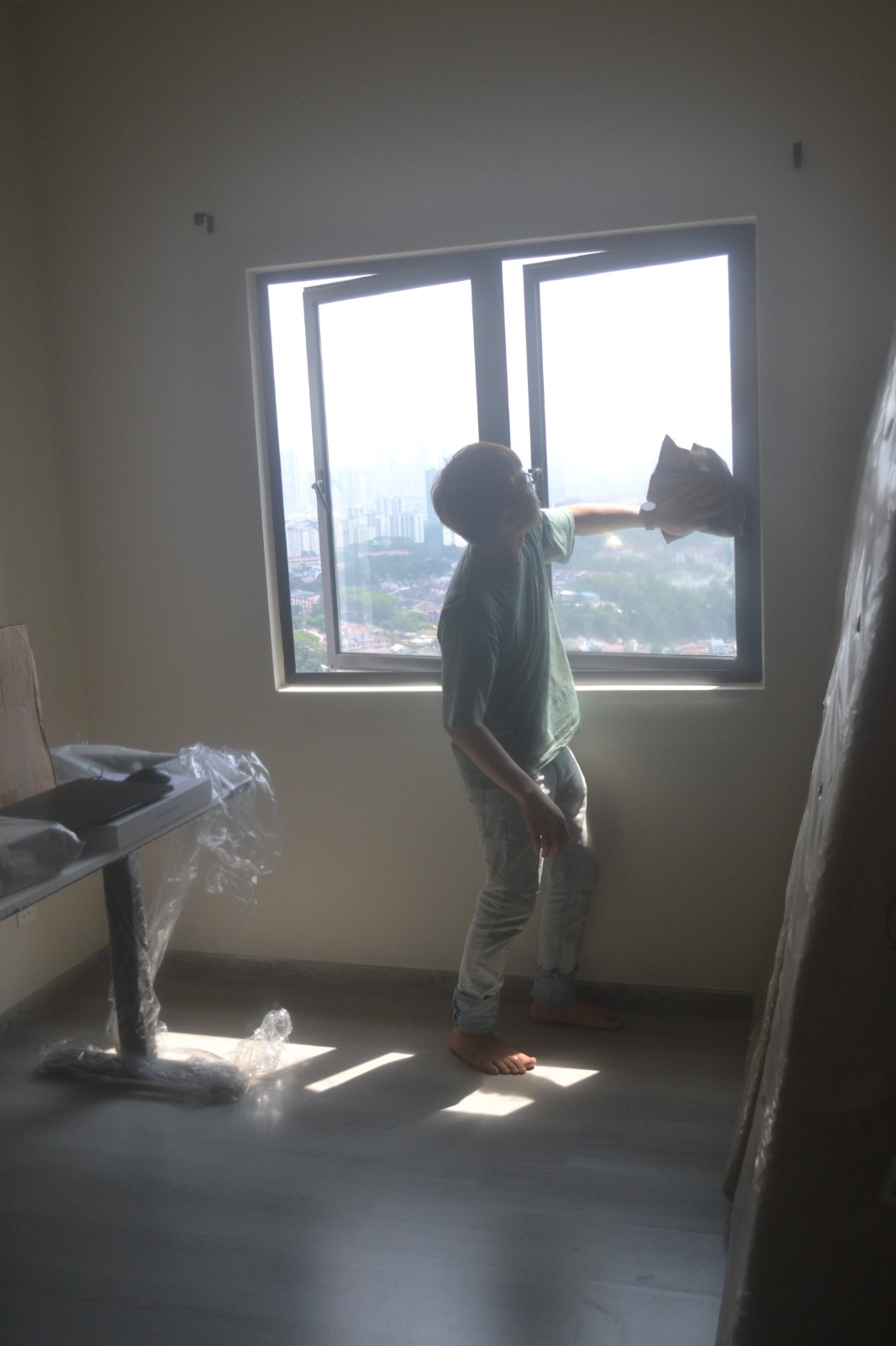 ServiceKru crew cleaning a high window sill in natural light