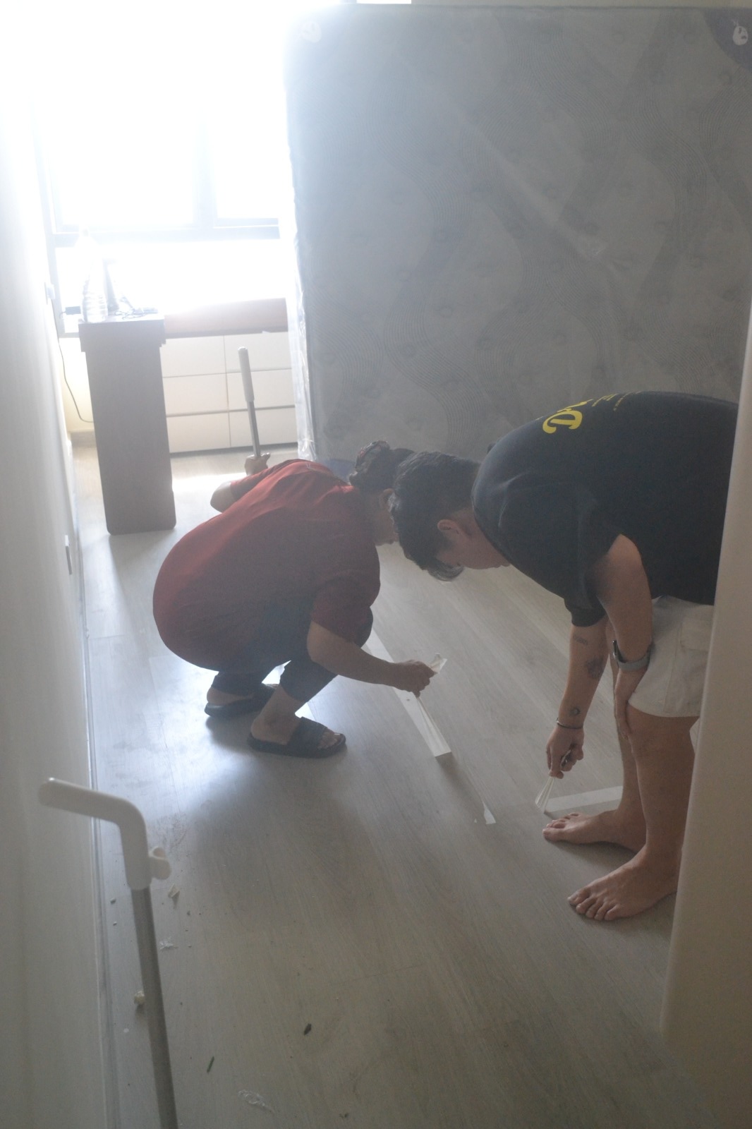 ServiceKru crew measuring and prepping the floor near a new mattress